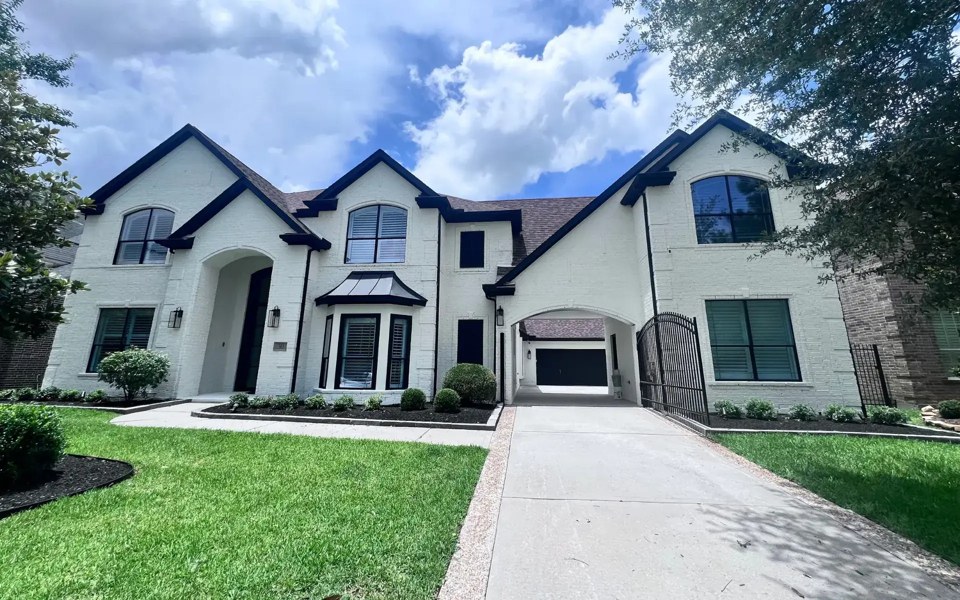 Painted brick ranch home with crisp white field and dark trim