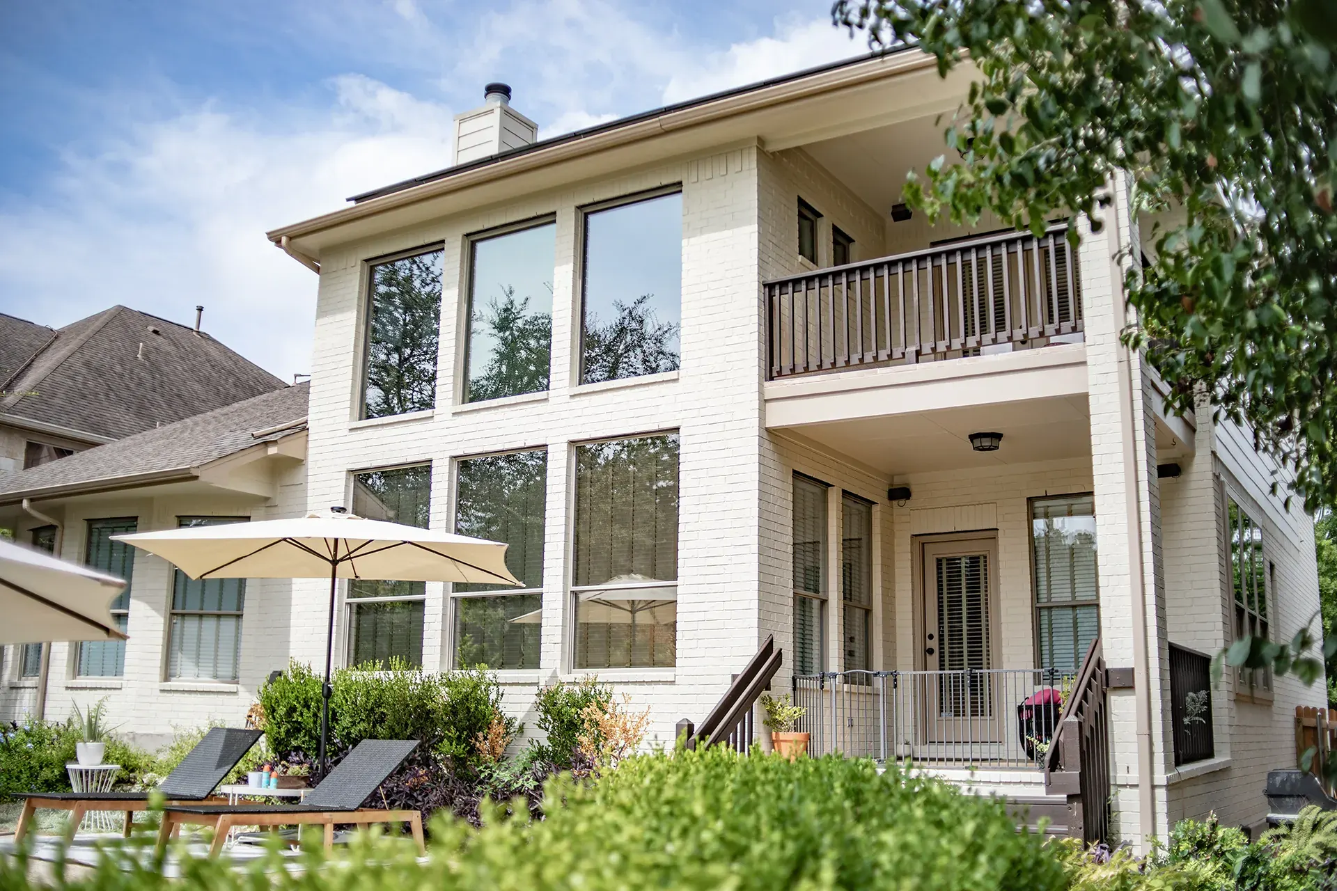 Painted brick home exterior with balcony and patio by That 1 Painter