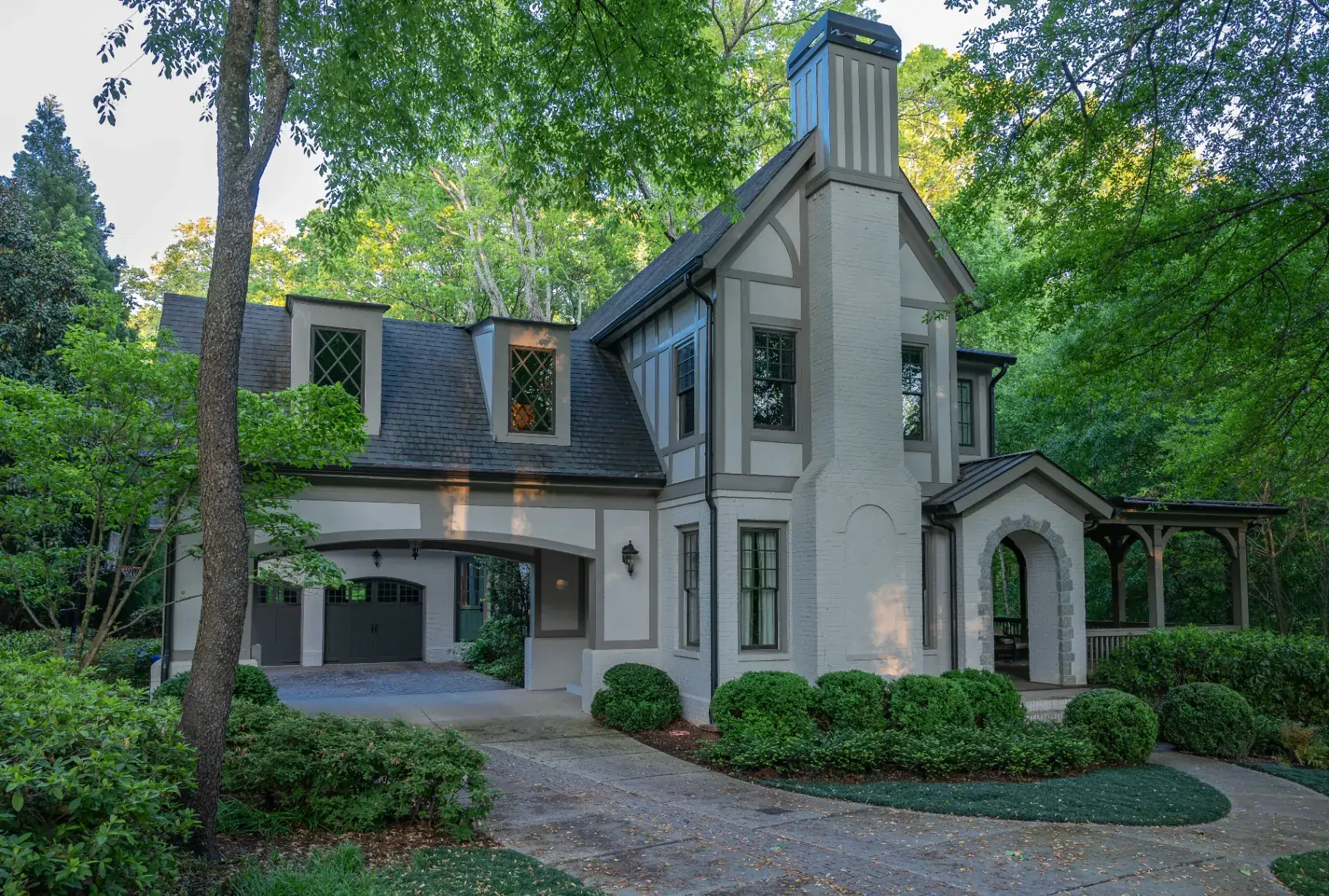 Tudor-style home exterior with painted brick, stucco accents, and timber detailing refreshed by That 1 Painter