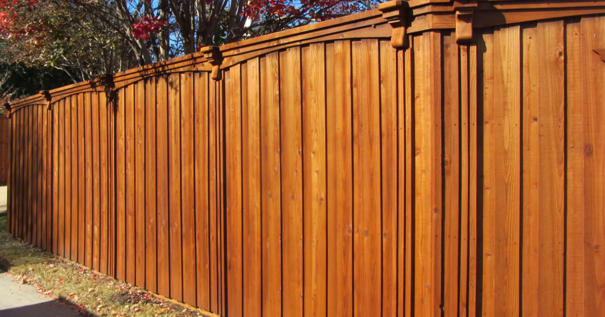 Wood picket fence with refreshed natural cedar stain finish