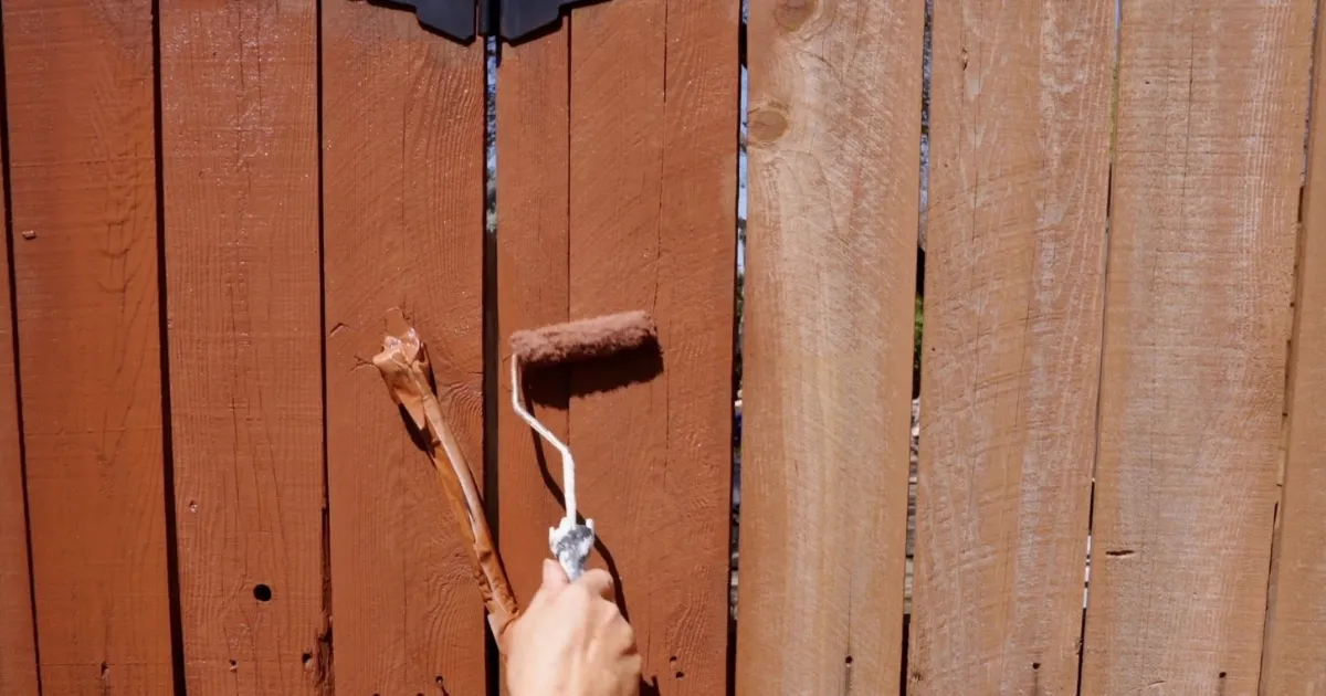 Backyard wood fence stained in rich walnut color