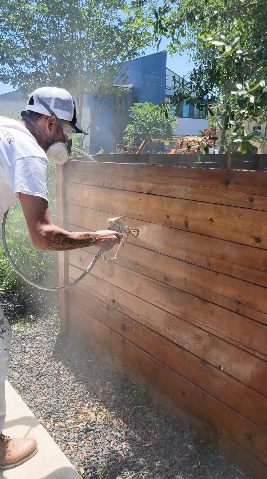 Long residential fence line stained in semi-transparent brown