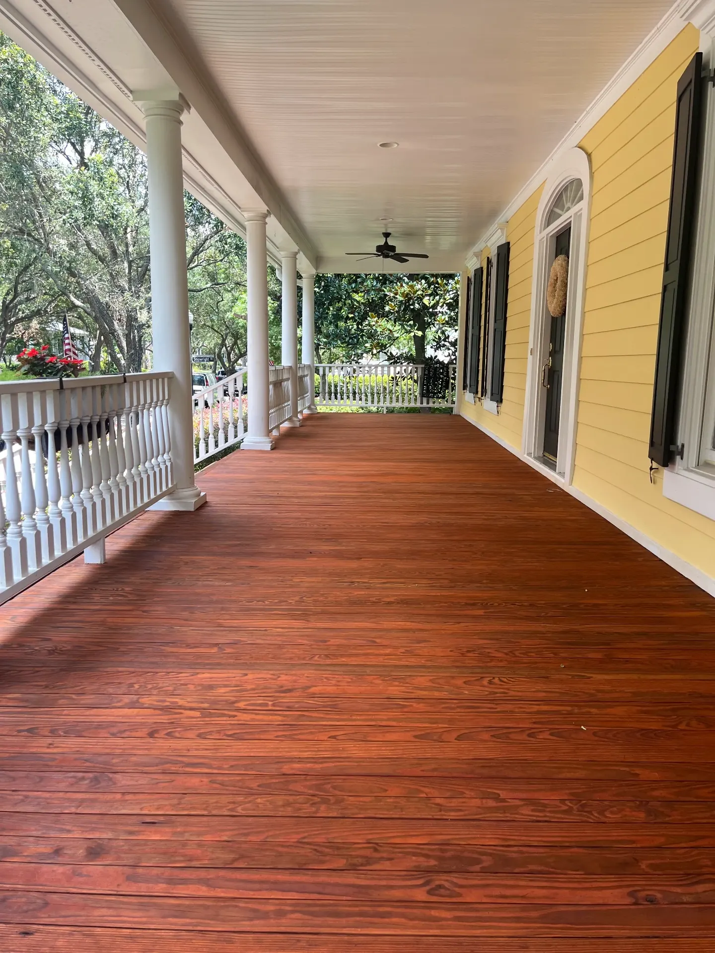 Historic front porch deck boards refinished in rich mahogany stain