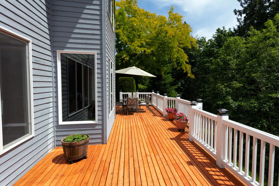 Wraparound wood deck after full pressure wash and stain with white railings