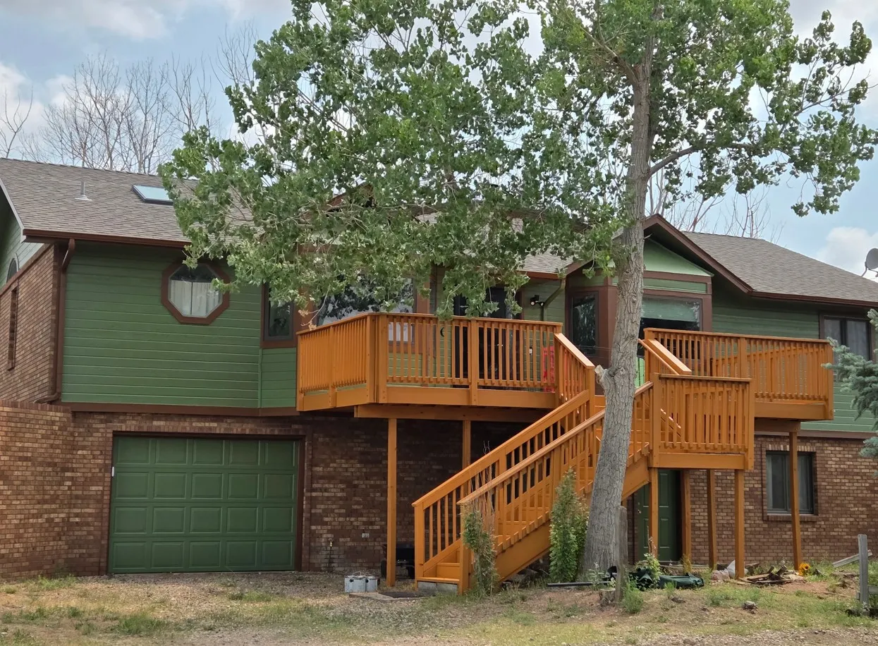 Two-story home with elevated wood deck and stairs freshly stained
