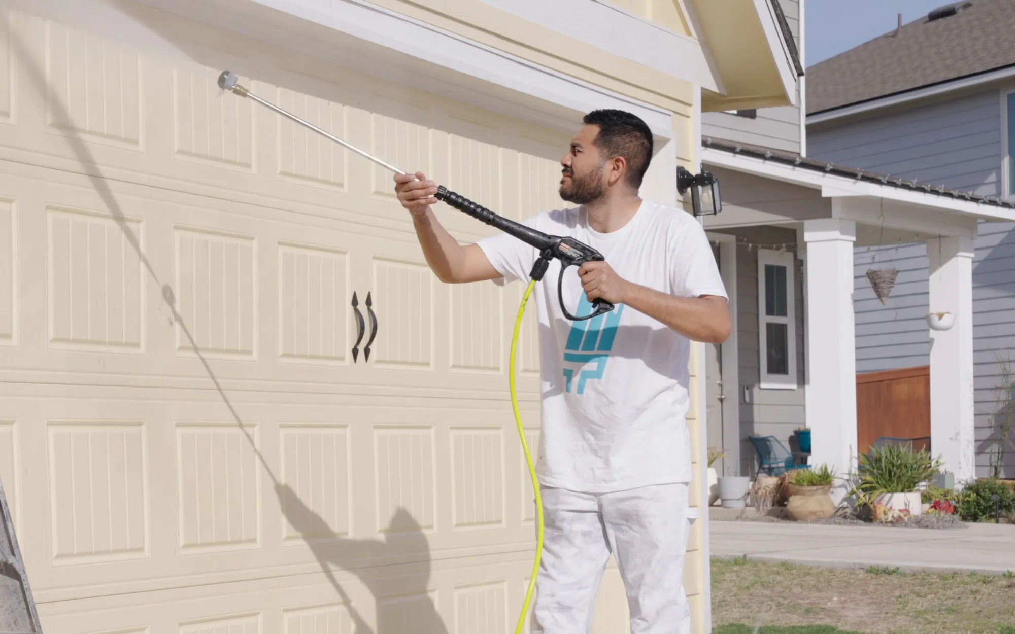 Painter pressure washing a garage door